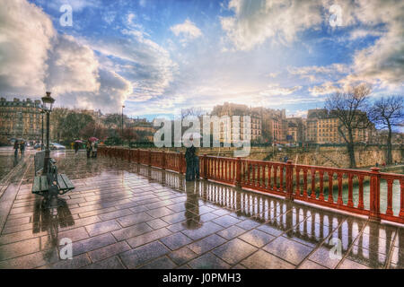 Lovers in the rain on the Pont au Double. France. Paris Stock Photo