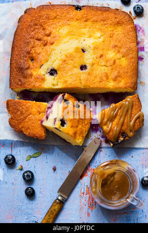 Blueberry cake with caramel sauce on blue surface Stock Photo