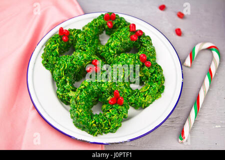 Christmas wreath cookies made of cornflakes, green colourant and candies Stock Photo