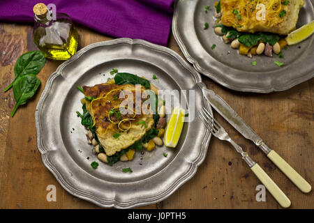 Hake on beans, sweet potato spinach salad Stock Photo