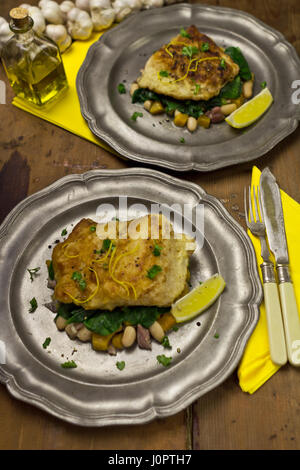 Hake on beans, sweet potato spinach salad Stock Photo