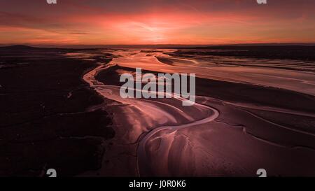 Sunset over the mudflats at low tide on the Loughor Estuary, Penclawdd, North Gower, Swansea. Stock Photo