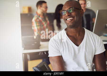 Contemporary African American businessman smiling and looking away in the office. Stock Photo