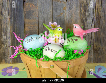inspirational words on Easter eggs in wooden basket with birds Stock Photo