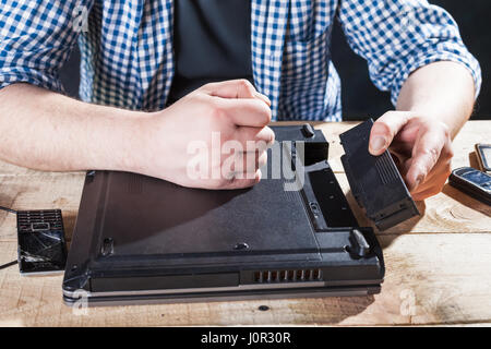 Service engineer disassembling broken laptop. Electronic devices repairing technology Stock Photo