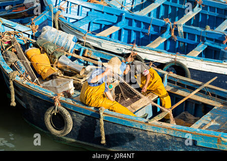 Morocco Essouira 20 January 2017 Fishermen working on nests on the boat, preparing for the fishing day. Essouira is a village based in Atlantic shore Stock Photo