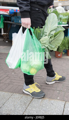 Young man carries his purchase in plastic bags of the weekly market Stock Photo