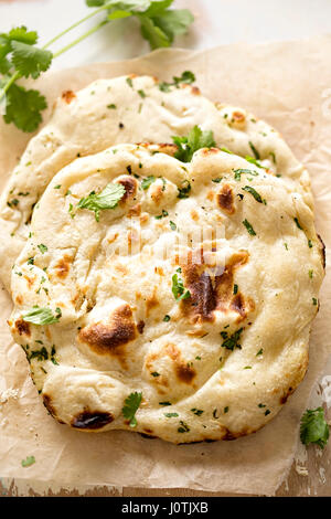 Coriander naan bread on wooden board Stock Photo