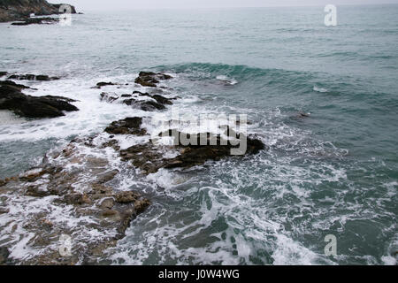 waves washing rocks shot on cloudy day Stock Photo