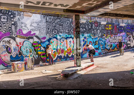 Teenager skater riding a skateboard performing an trick in Leake Street tunnel, London, UK. Leake street also known as 'Graffiti Tunnel' or the 'Banks Stock Photo