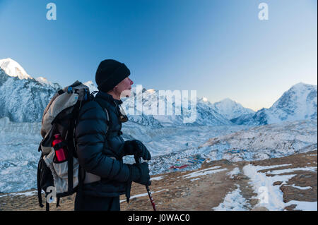 A female trekker on the descent from Kala Pattar, with Gorak Shep in the background, Nepal Himalaya. Photo © robertvansluis.com Stock Photo