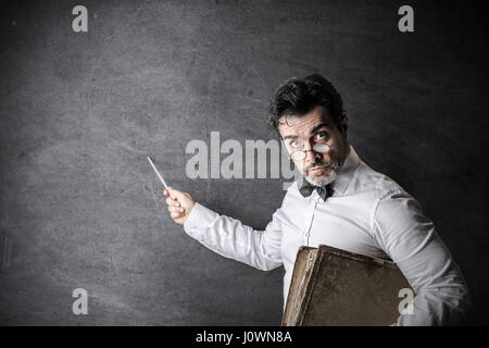 Serious man teaching on blackboard Stock Photo