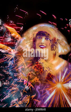 Creative collage of a  smiling, beautiful 1920's flapper girl wearing a drape hat surrounded by exploding fireworks isolated on a black background. Stock Photo