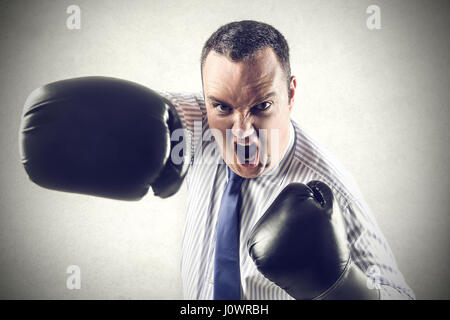 Businessman in boxing gloves punching Stock Photo