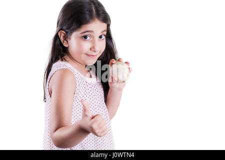 Happy small beautiful girl with dark hair and eyes holding white onion on hands and thumbs up looking at camera and smiling. studio shot, isolated on  Stock Photo