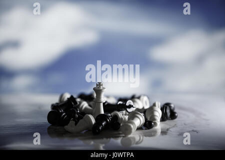 One chess is staying against full army of chess pieces. Chess strategy concept is on the bright background. Selective focus shallow depth field. Stock Photo