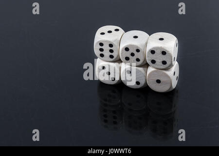 Worn white dices on a black glossy background Stock Photo