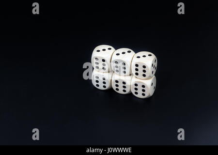 Worn white dices on a black matte background Stock Photo