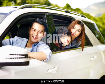 happy asian family traveling by car looking at camera smiling. Stock Photo