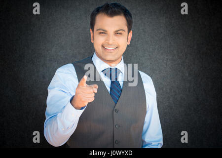Closeup portrait, smiling handsome, excited, happy man pointing at you camera gesture with finger, isolated gray black background. Positive human emot Stock Photo