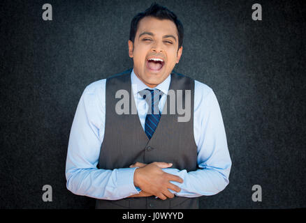 Closeup portrait of handsome, burst out laughing young business man, worker, employee, isolated gray black background. Positive human emotions facial  Stock Photo