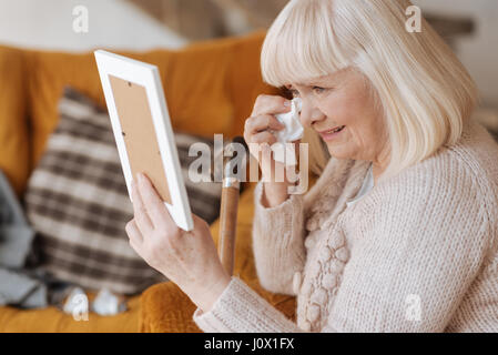 Sad crying woman wiping away her tears Stock Photo