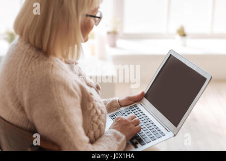 Nice grey haired woman typing Stock Photo