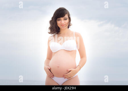 Pregnant woman Standing on beach Stock Photo