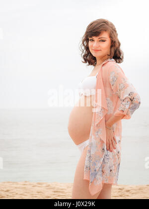 Pregnant woman Standing on beach Stock Photo