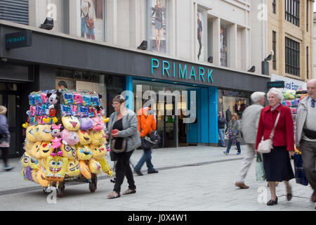 Primark on Queen Street, Cardiff. Vendors in the foreground are selling emoji cushions etc. Stock Photo