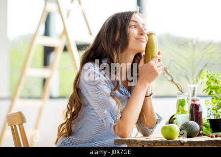 Woman with green healthy food and drinks at home Stock Photo