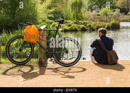 A man relaxing on a summer's day at Barnes Pond in London, England UK. Stock Photo