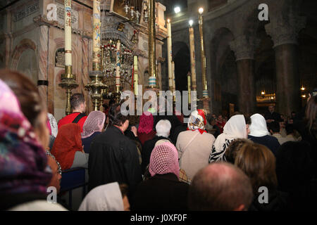 Armenian worshippers and tourists attend the Armenian Easter Sunday Mass in the Rotunda in front of the Aedicule containing the Holy Grave of Christ. Stock Photo