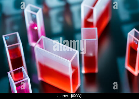 Quartz cuvette for laser chromatography with red liquid. Physical chemistry laboratory Stock Photo