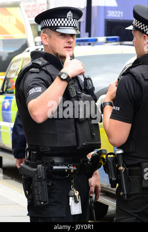 Armed police who were on routine patrol in Glasgow attend a road traffic incident in the city's Argyle Street during the Commonwealth Games Stock Photo