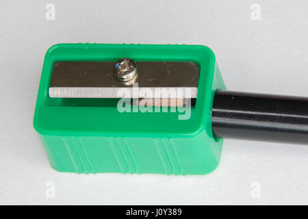 Green pencil sharpener with a black pencil on a white background Stock Photo