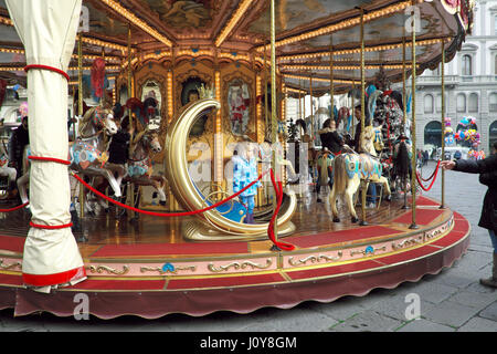 Barbie's daughter in Wonderland - Blonde female child on a carousel (merry-go-round) at rides in central Florence (Firenze), Tuscany, Italy, Europe Stock Photo