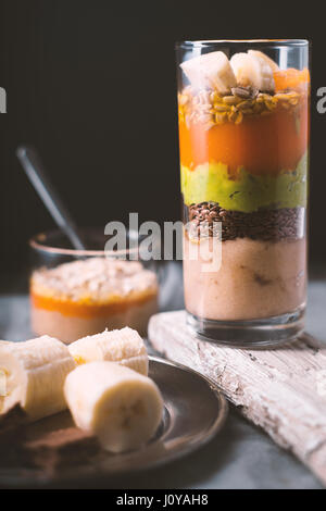 Banana smoothie, flax seed, avocado, pumpkin layers side view vertical Stock Photo