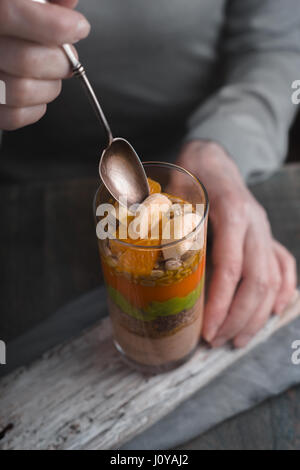 Woman eating a smoothie with avocado and pumpkin side view vertical Stock Photo