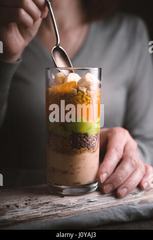 Woman eating a smoothie with avocado and pumpkin vertical Stock Photo