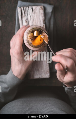 Woman eating a smoothie with avocado and pumpkin top view vertical Stock Photo