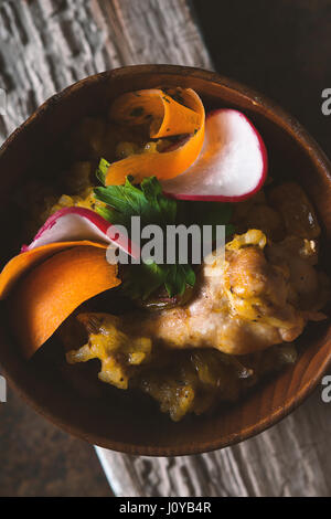 Salad of beans, chicken, carrots, radishes in a wooden bowl vertical Stock Photo