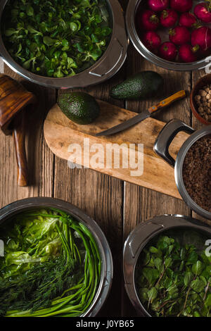 Avocado, green herbs in a bowl of water on the table vertical Stock Photo