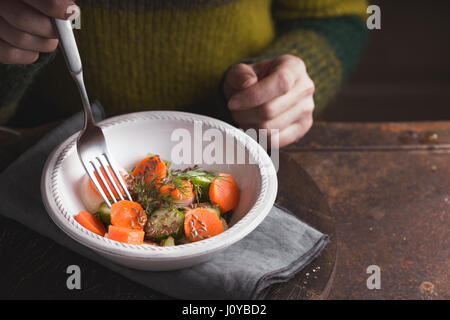 Eating vegetable salad  on the metal background horizontal Stock Photo