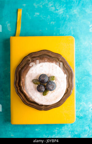 Cake with blueberry on a yellow notebook free space Stock Photo