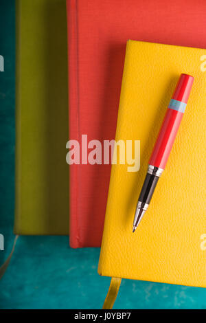 Color pads and a pen on a turquoise table Stock Photo