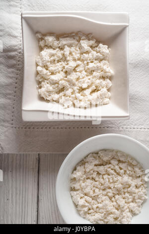 Cottage cheese in ceramic bowls on a linen napkin Stock Photo
