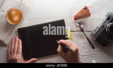 Tablet, camera, coffee cup, cake on white table Stock Photo