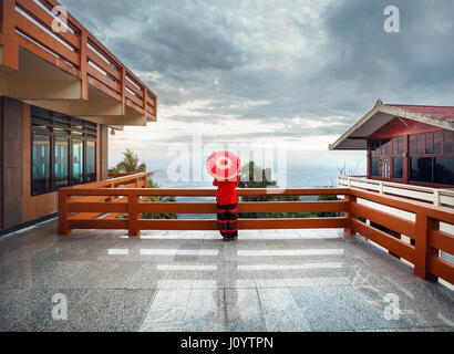 Woman with red Thai umbrella at view point looking at Chiang Mai city panorama at sunset in Thailand Stock Photo