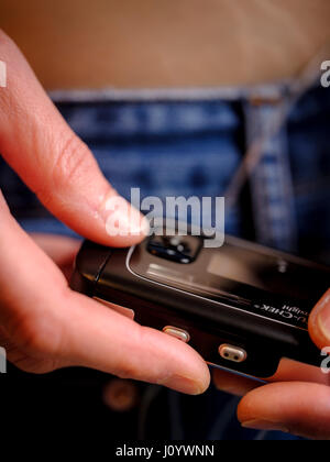 A woman with Type 1 diabetes using an insulin pump and continuous glucose monitor. Stock Photo